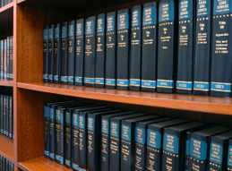 Image of a bookshelf containing two rows of dark blue law books